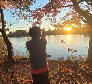 Hiking child overlooking pond during sunset