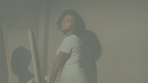 Femme devant un mirroir. elle regarde ailleurs avec un air mélancolique