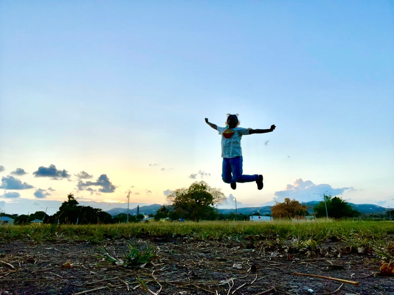 Author, Carley, hopping joyously in an open field of St. Croix, Virgin Islands.
