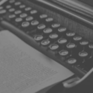 a close-up image of an old fashioned typewriter showing the keys and typing on the paper_e