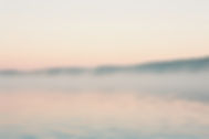 tranquil-misty-lake-sunrise-with-hazy-hills-distance.jpg