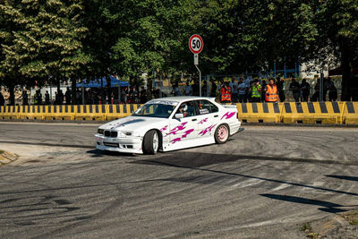 BMW E36 bianca con grafiche viola in traverso