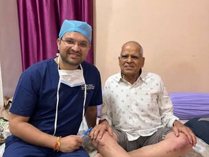 डॉ. आशीष सिंघल के साथ 90 वर्षीय मरीज भुरा लाल तेली, रोबोटिक घुटना प्रत्यारोपण के एक महीने बाद पालथी मारकर बैठे हुए
