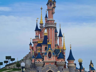 The Disneyland Paris castle - a tall, fairytale inspired castles with beautiful pink walls and blue or gold tower roofs
