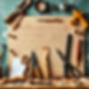 A board with several randomly distributed woodworking tools and stationery for a wallpaper