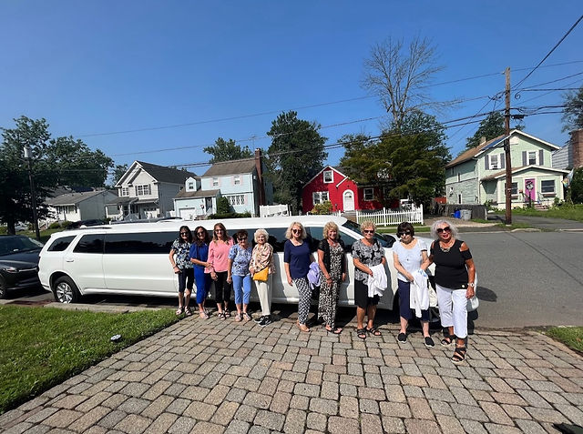 people are standing and there is a SUV limousine in the background