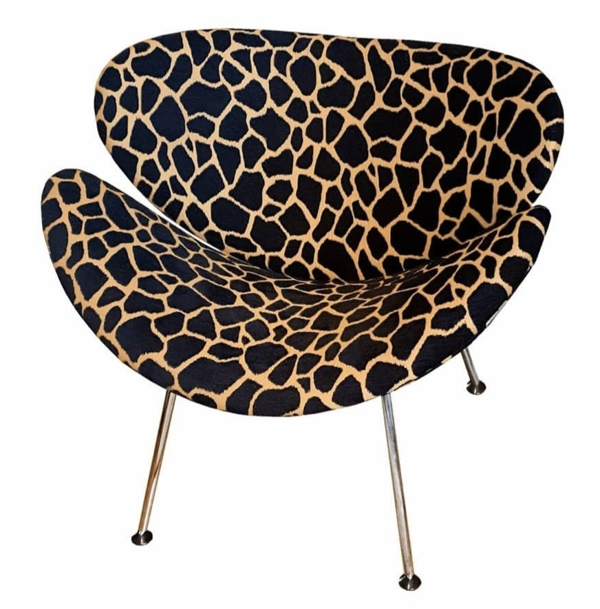 iconic Orange Slice Chair, a 1960s design featuring two curved shells. covered in black & gold giraffe print. stunning