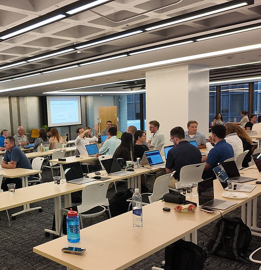 Teams collaborating during an interactive AI workshop with laptops and group discussion