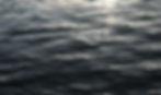 Calm rippling water reflecting sunlight, symbolizing grounding in the present moment for managing anxiety naturally