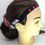 Thumbnail: Headband with red hearts, on a mannequin head, Adjustable Hearing Aid Headband, side view.