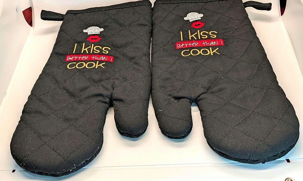Black oven mitts with embroidered text: I kiss better than I cook