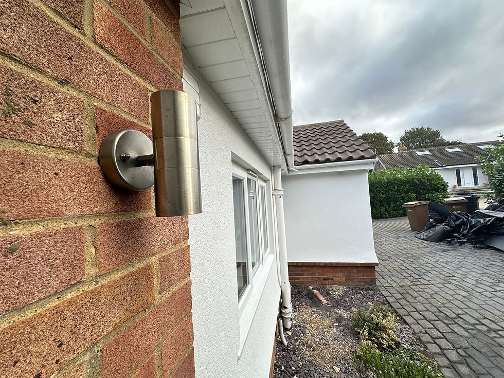Brickwork meeting a white rendered wall, with soffit and fascia above