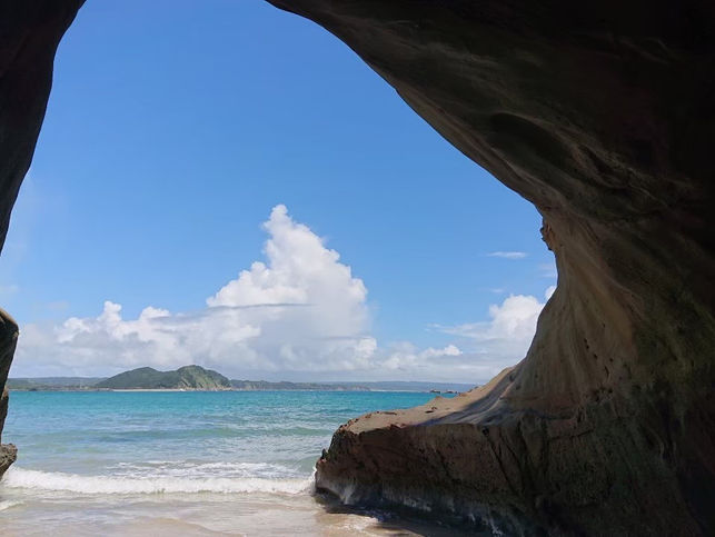 岩の間からのぞく青い海と空