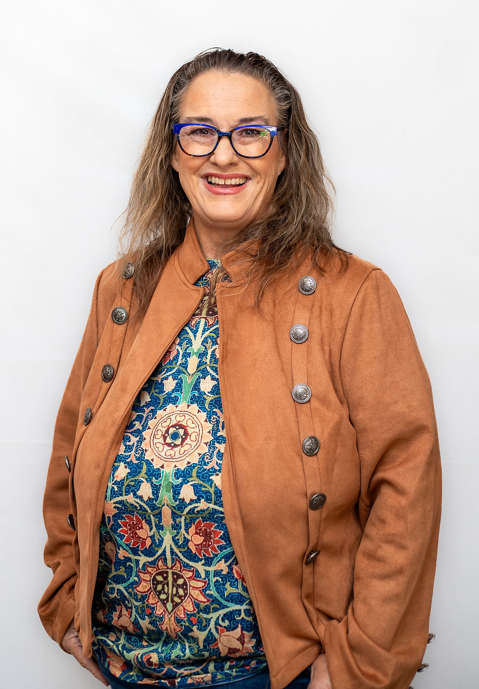 Confident woman in glasses wearing a brown jacket, professional business portrait on a neutral background.
