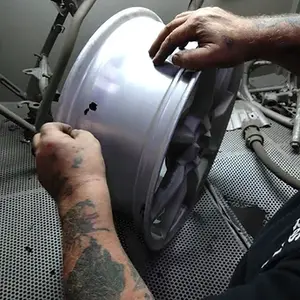 Mechanic inspecting motorcycle wheel