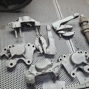 Grey motorcycle parts arranged, ready for painting, in a workshop