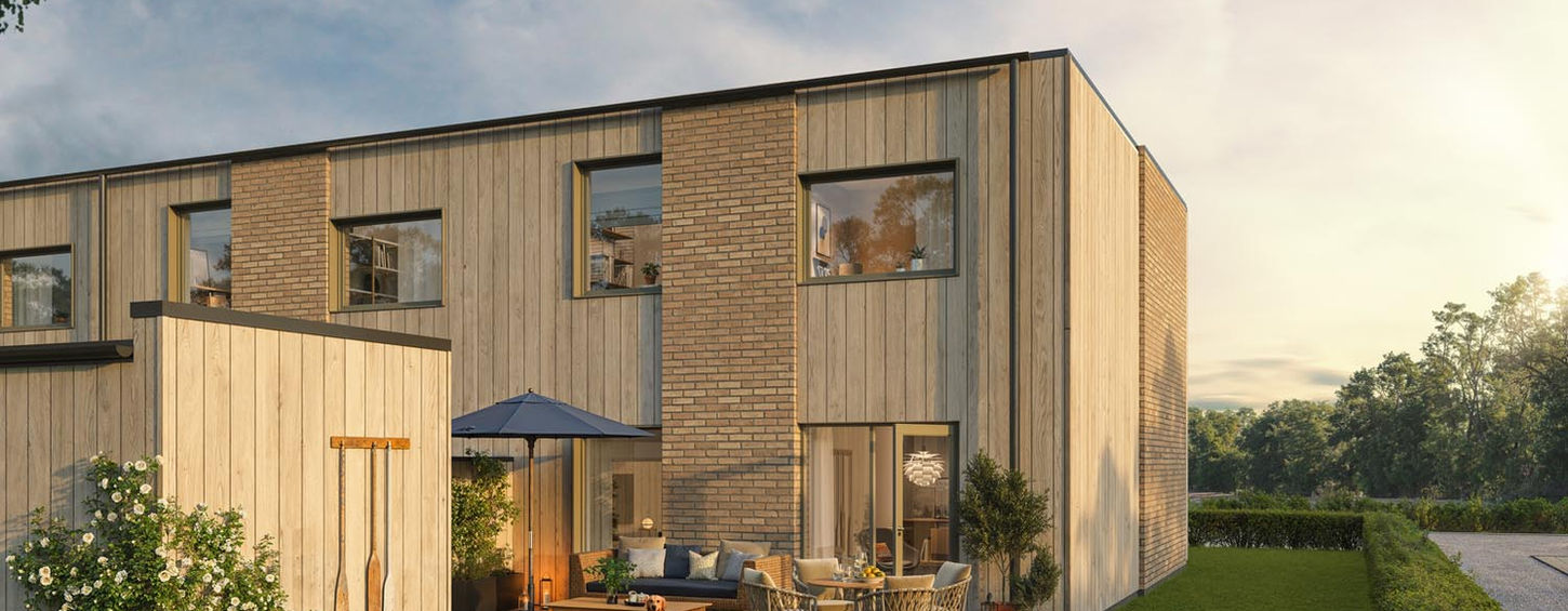 Modern townhouse with outdoor seating, CoForma Bostad, green lawn, sunny day.