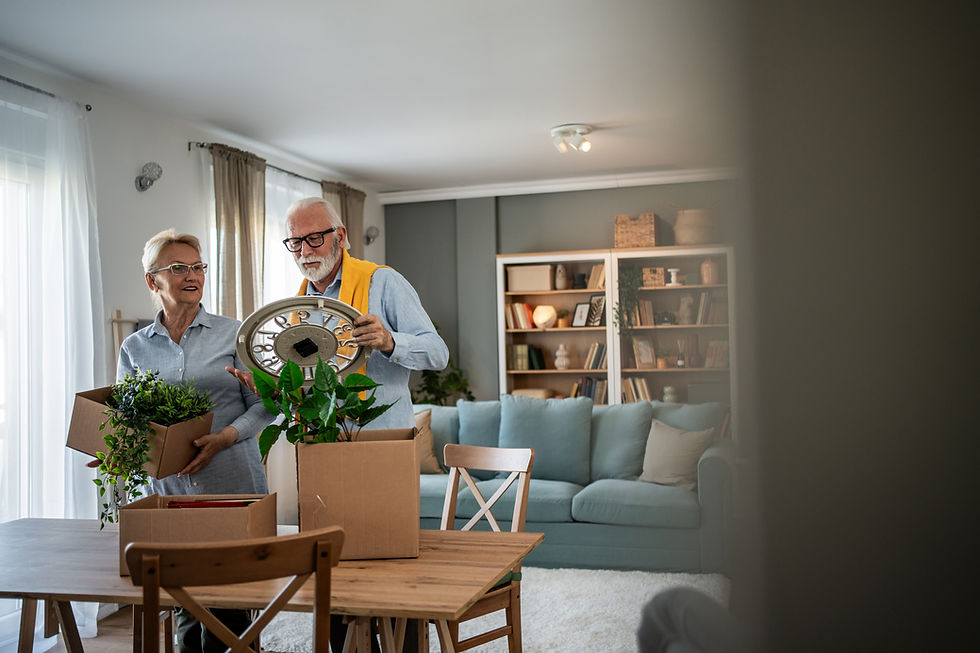 Äldre par packar upp inredning och växter i nytt hem