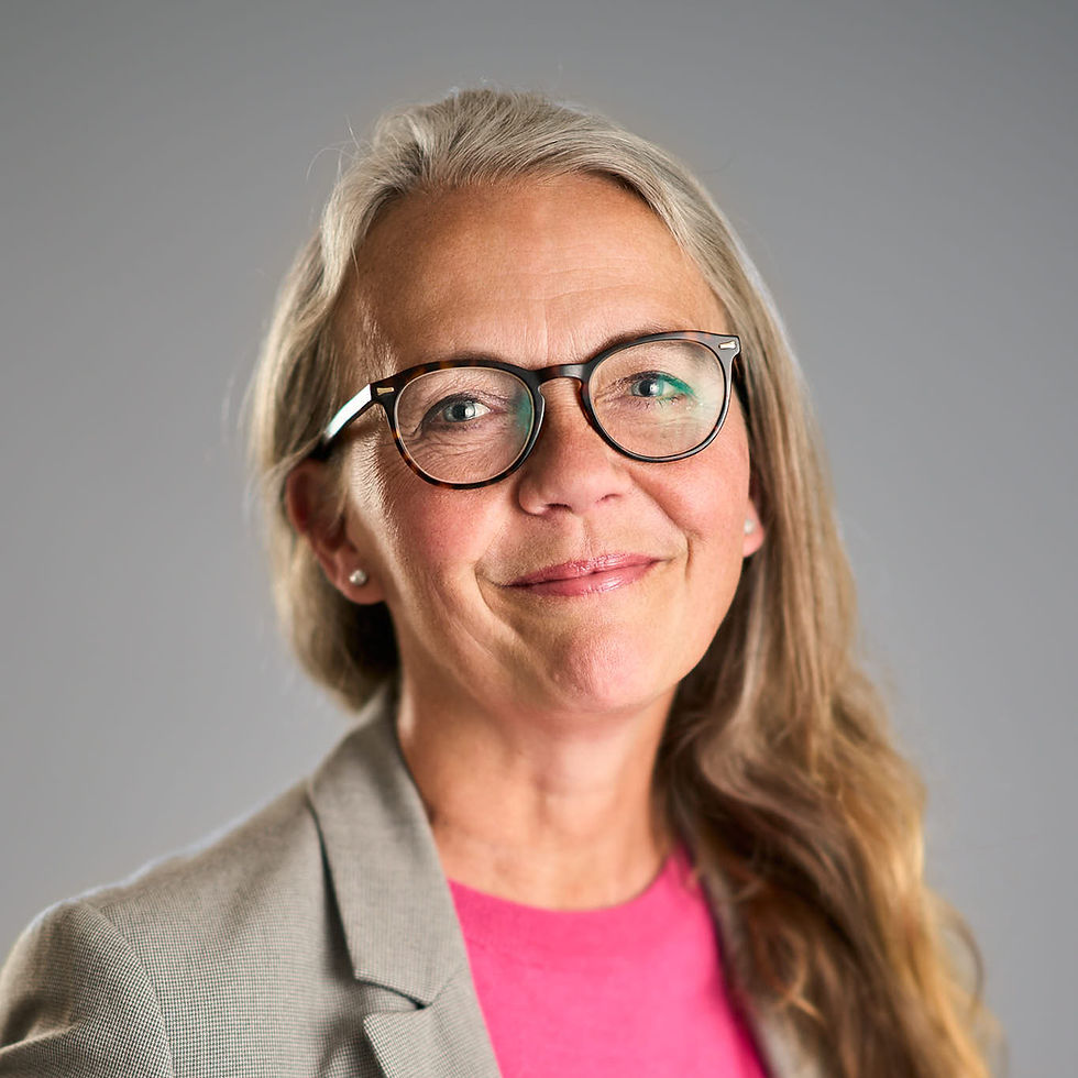 Petra Greby, kvinna med halvlångt hår och glasögon ler mot kameran