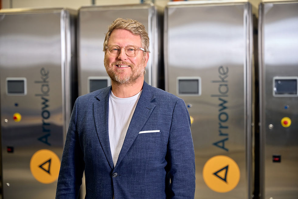 Man in blue blazer standing in front of Arrowlake equipment