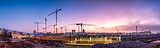 Byggkranar vid solnedgång över en byggarbetsplats, CoForma Bostad under konstruktion.