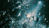 Bubbles rising in dark blue water with light rays