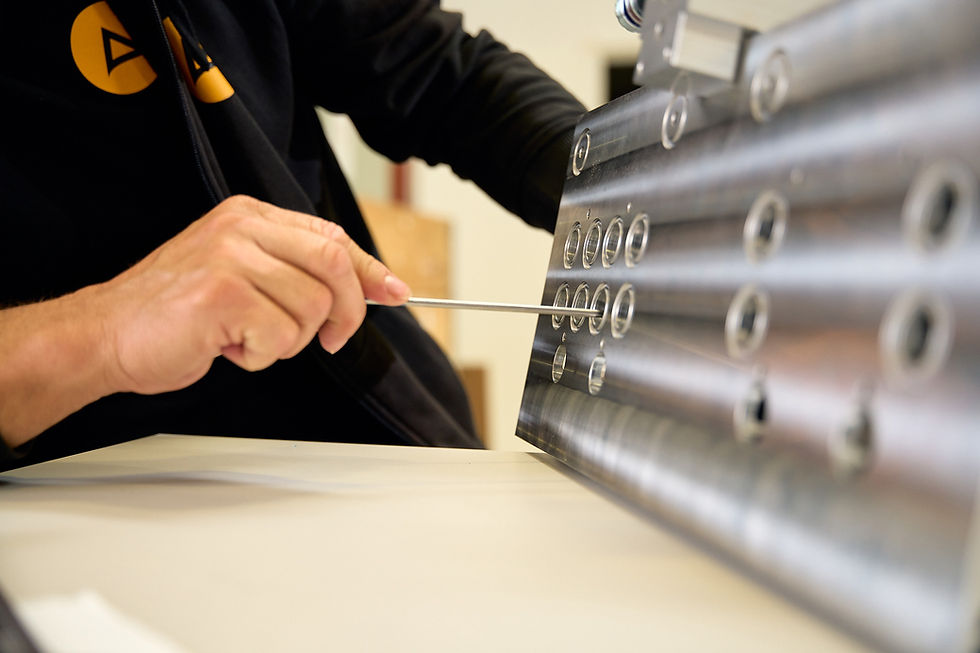 Technician using a tool on a metal component.