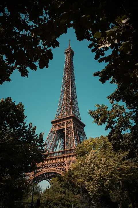 Der Eiffelturm von Paris durch die umliegenden Bäume fotografiert