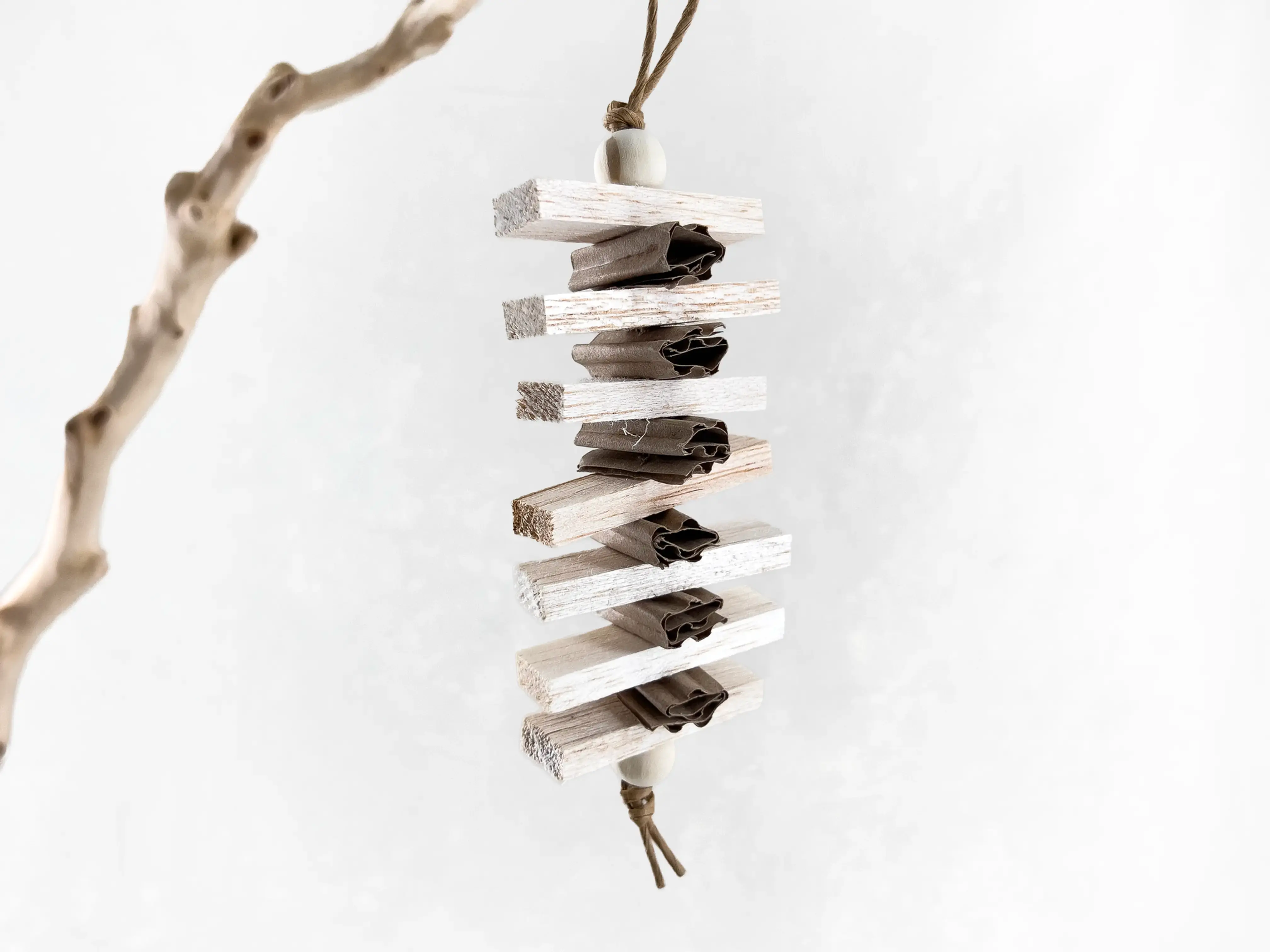 Small parrot toy and bird shredding toy made of natural balsa wood, cardboard paper, wood beads, and paper rope.
