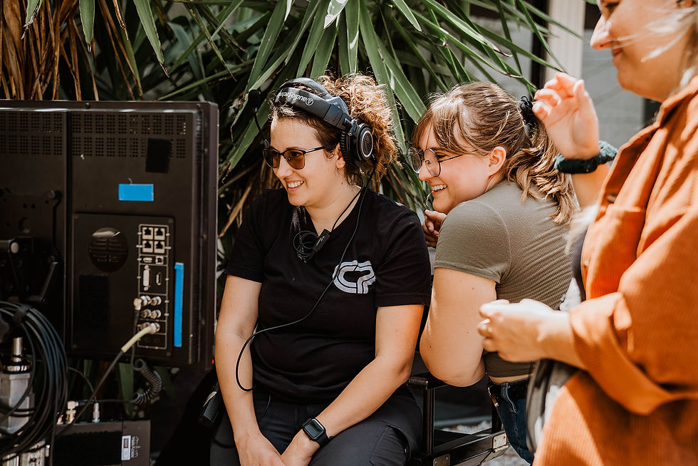 A director and art designer sit at the monitor to watch a scene play out.