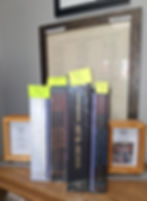 D&D books on a shelf with price tags, framed text and signs about book purchasing. Background features an Iowa City directory.