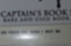 Close-up of a book label reading "CAPTAIN'S BOOK SHOPPE: RARE AND USED BOOKS" above "DD FORM NO. 256A 1 MAY 50" on a pale background.