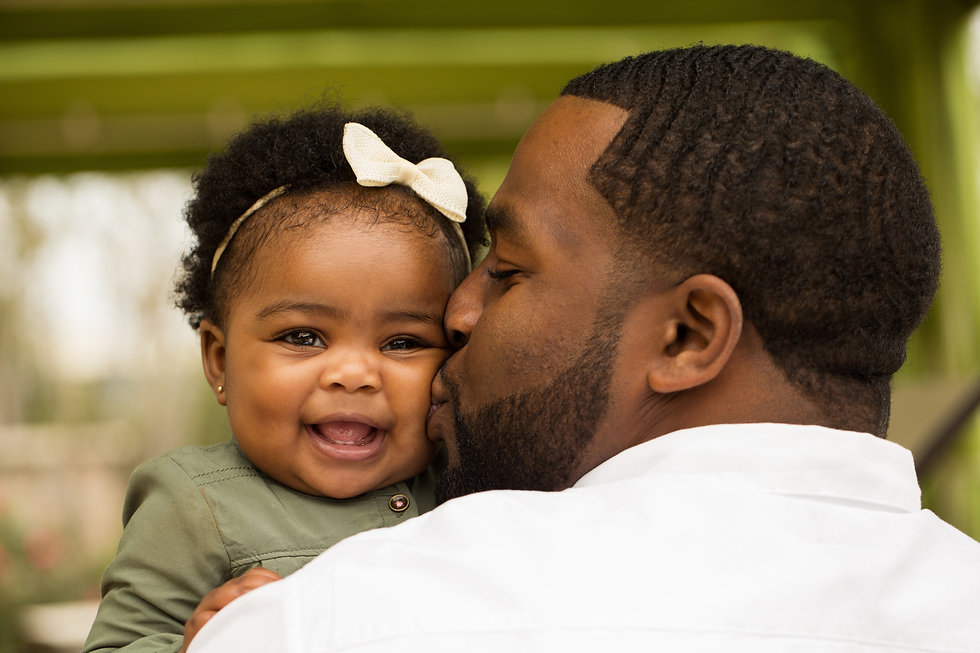 baby girl w bow kissed by dad.jpeg