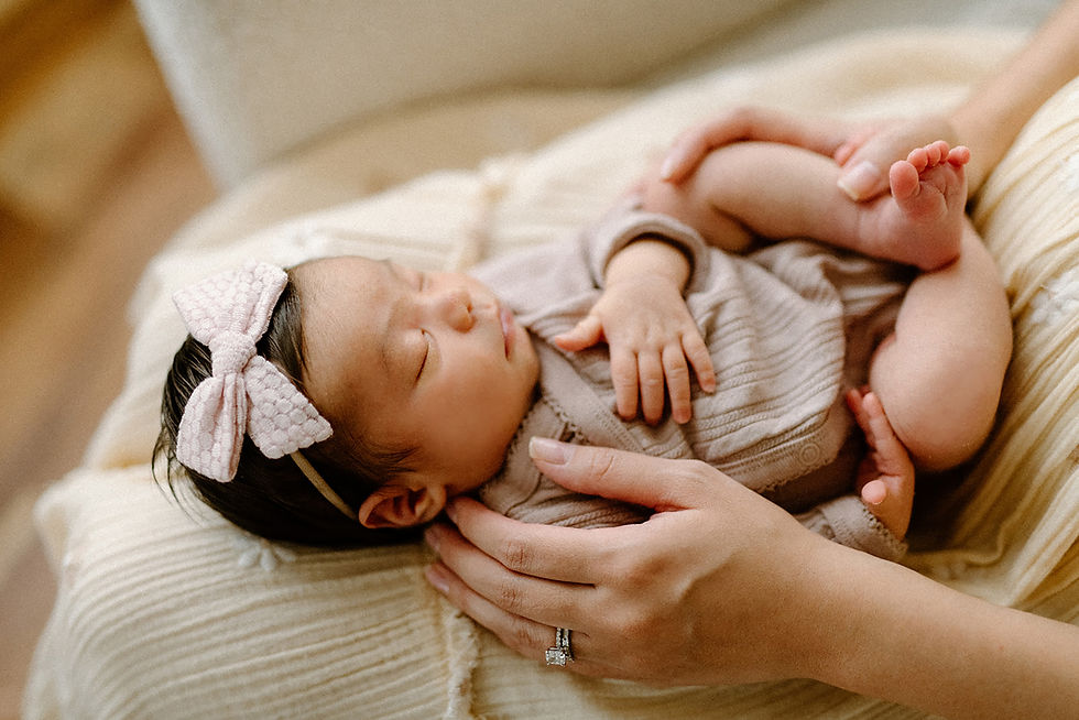 Mother gazing lovingly at newborn baby girl in natural light studio