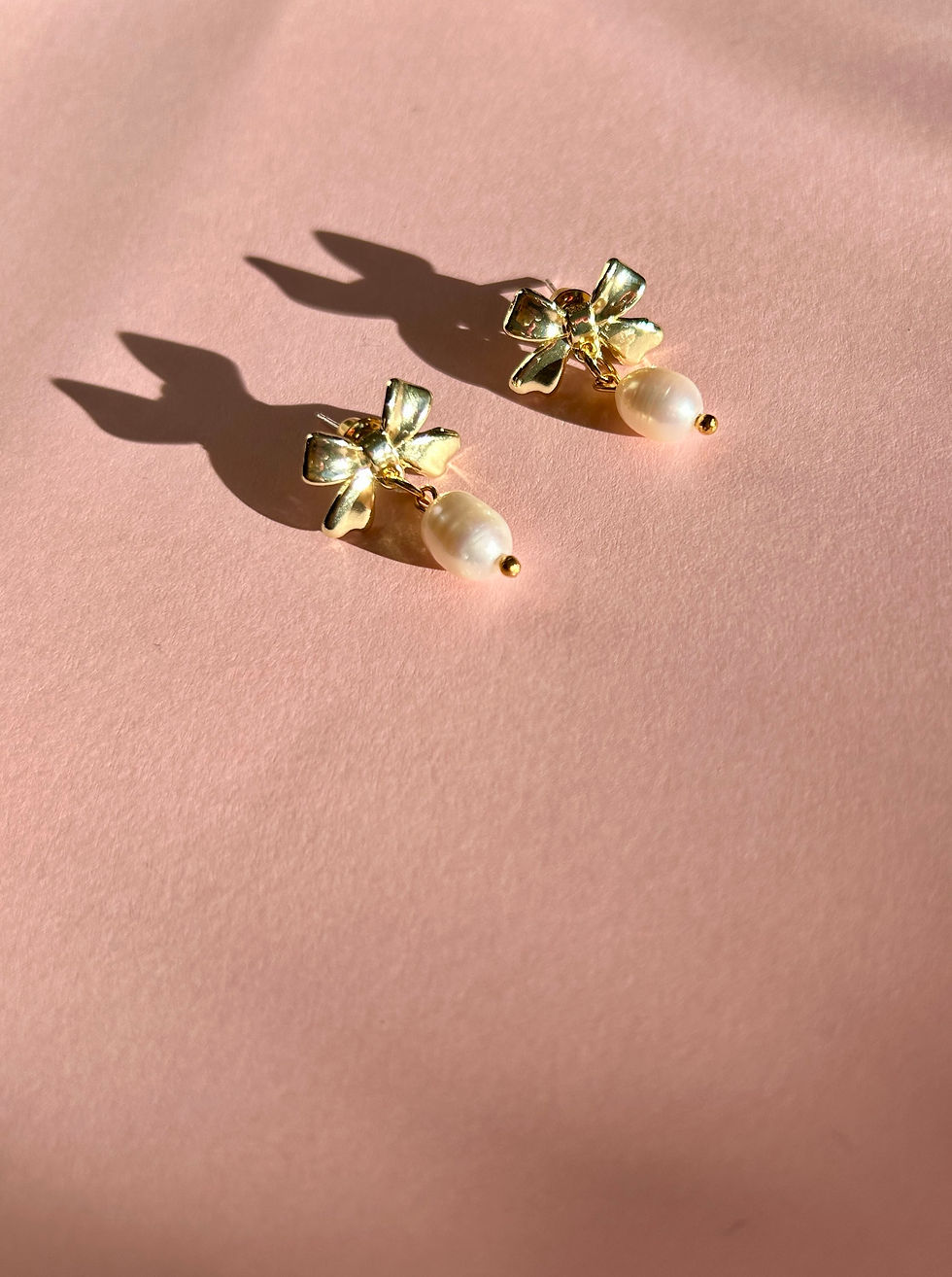 Thumbnail: Gold plated bow earrings with freshwater pearl charms