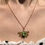 Thumbnail: 24k gold plated chain necklace with brass flower & green gem charm pendants on pink background