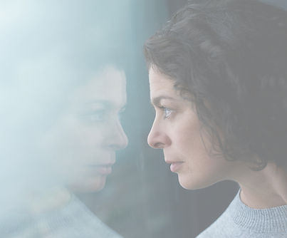Young woman looking at her reflection in the window_edited.jpg