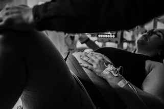 Moeder die hand op haar buik legt tussen de weeen door.