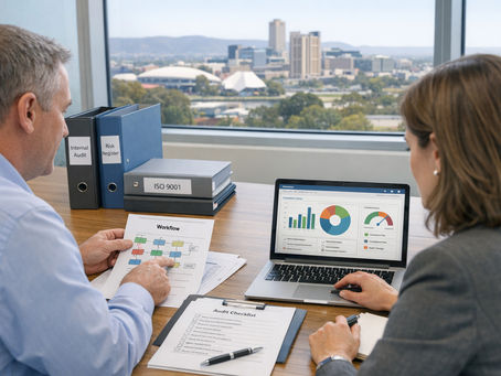 Two business people preparing for an audit in an office overlooking Adelaide city.