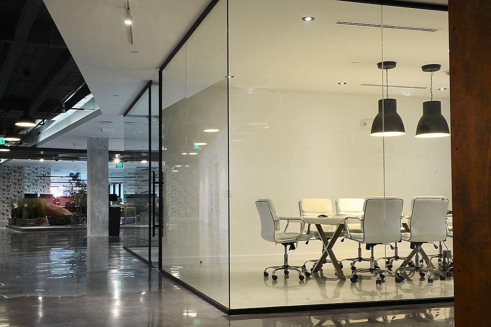 Frameless glass wall partition enclosing a modern office conference room with natural light and clean architectural lines.
