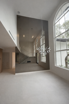 Custom bronze mirror wall reflecting staircase in a contemporary luxury home