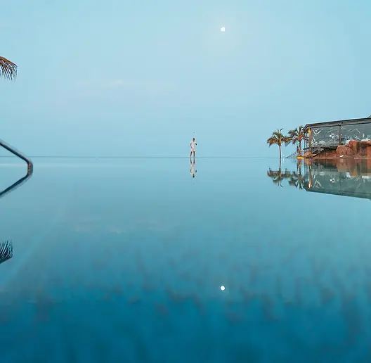 Minimalistisches Poolbild bei Vollmond in Gran Canaria – ruhige Wasserfläche mit tropischer Kulisse