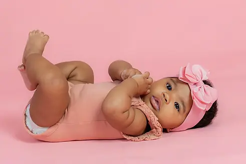 Bebé pousado fundo rosa