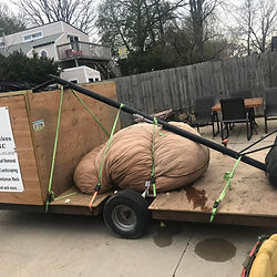 Basketball hoop loaded onto a trailer with other trash to be thrown away. Hauled to the landfill.