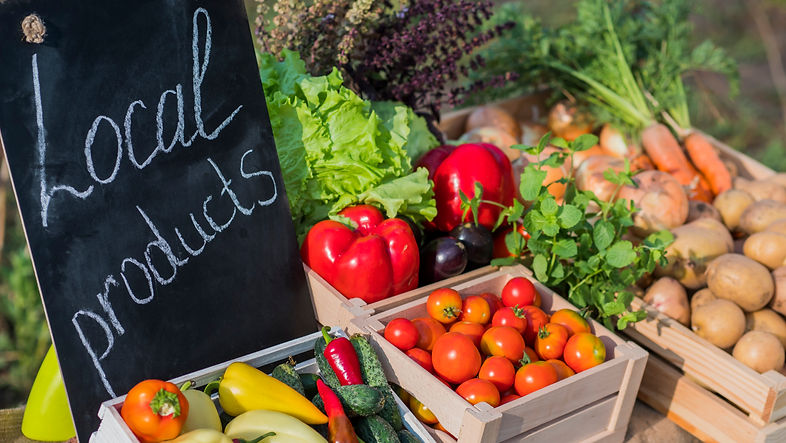 Counter with fresh vegetables and a sign of local products.jpg