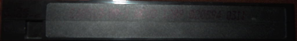 The bottom of a black VHS cassette with the print date info printed in black ink for whatever reason.