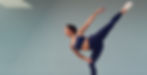 A woman looking down while engaged in an active pilates pose.