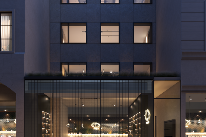 Blue-hour front facade with illuminated interiors.