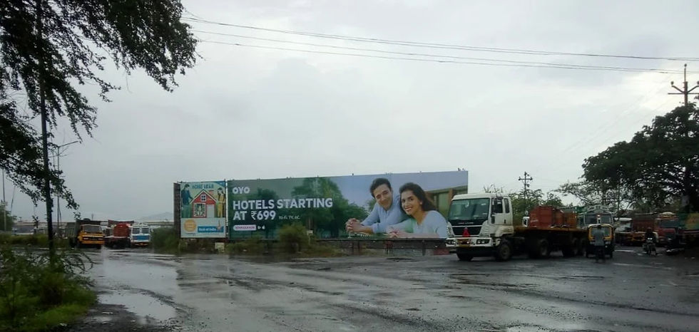Billboard in a rainy cityscape shows smiling couple with text OYO Hotels