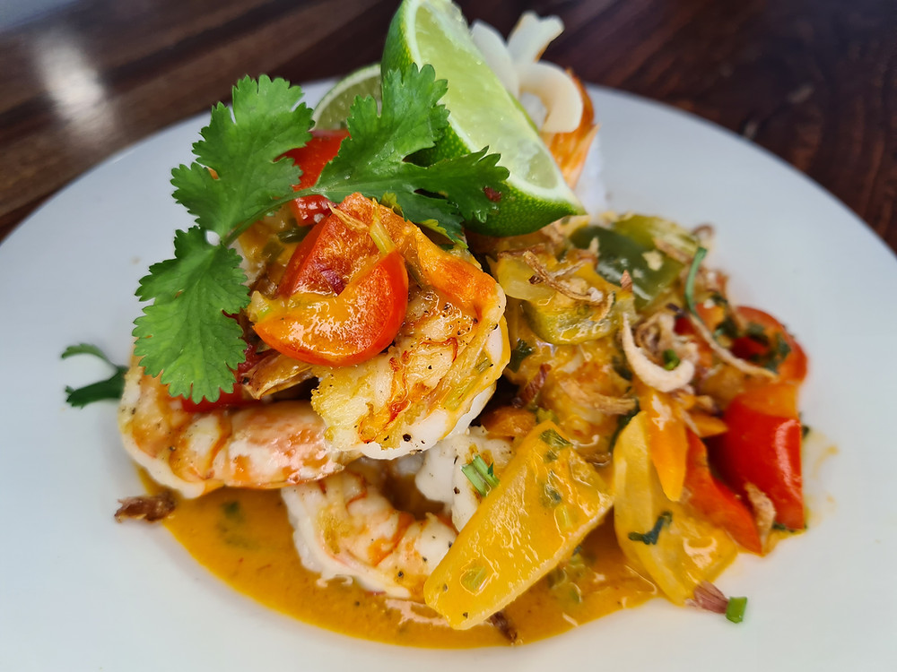 Malaysian king prawn curry with coconut rice, lime wedges and coriander